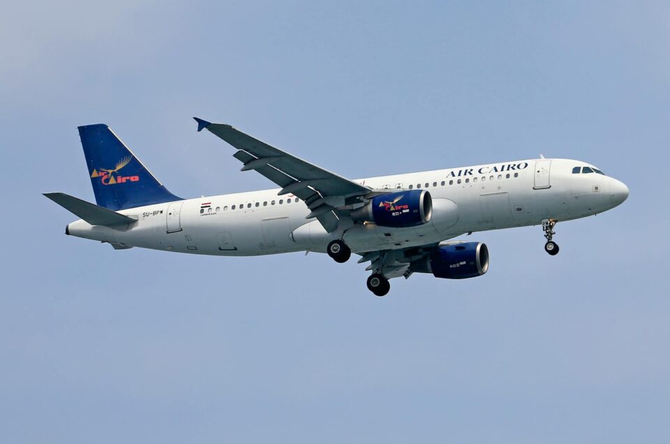 Air Cairo Airbus A320 flying against a blue sky, showcasing the airline's logo and design.